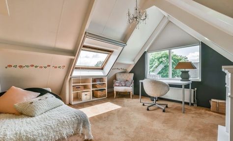 A cozy attic bedroom with carpet lighting fixtures bed shelves table with chair and an armchair by the window Decorate Slanted Walls, Decorate A Slanted Wall, Decorating Slanted Walls, Bedroom Slanted Walls, Slanted Wall Bedroom, Cozy Attic Bedroom, Decor Ideas For Bedroom, Slanted Walls, Cozy Attic