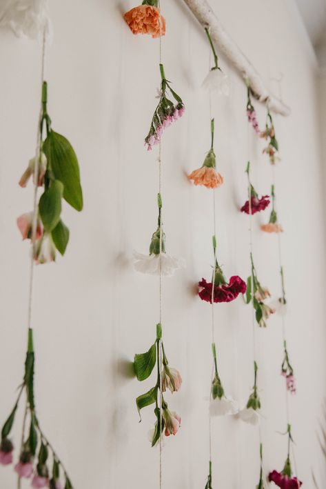 Hanging Single Flowers, Hang Flowers On Wall, Hanging Flower Wall Diy, Wildflower Hanging Garland, Diy Floral Garland Backdrop, Diy Flower Hanging Decor, Hanging Wildflower Backdrop, Diy Hanging Flower Garland, Diy Flower Garland Backdrops