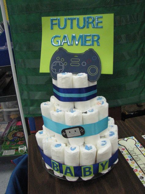 video game-y diaper cake Video Game Gender Reveal Ideas, Video Game Baby Shower Theme, Gamer Baby Shower Ideas, Video Game Baby Shower Ideas, Gamer Gender Reveal, Gamer Gender Reveal Ideas, Gamer Baby, Unique Diaper Cakes, Modern Baby Shower Games