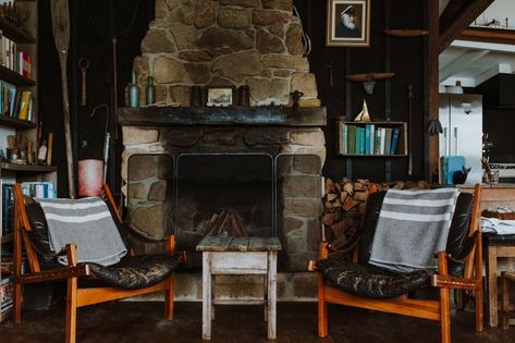 Living Room, Medium Hardwood Floor, Chair, Coffee Tables, Wood Burning Fireplace, and Shelves Sea breezes keep The Little Black Shack cool in summer, while a hand-built sandstone fireplace warms the property in winter.  Photo 7 of 11 in A 1920s Fisherman’s Shack in Australia Breathes New Life as a Cozy, Unique Rental Sitting Nook, Sandstone Fireplace, Eco Cabin, Beachfront Cottage, Fishermans Cottage, Beach Shack, Indoor Fireplace, Comfortable Bedroom, Scandinavian Home