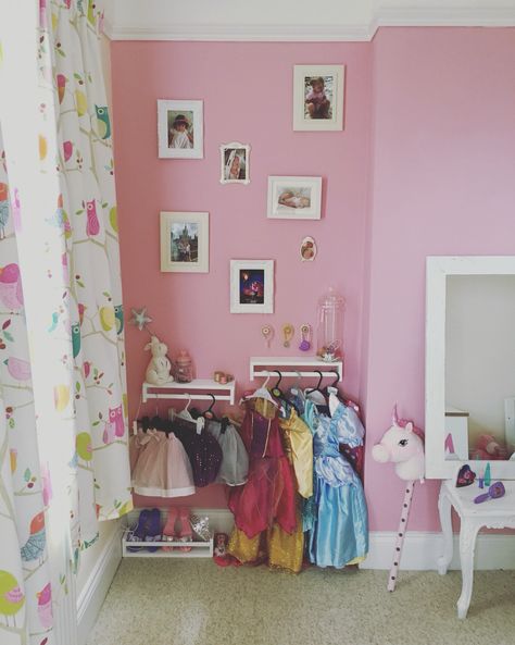 Girls bedroom dress up Dress Up Play Organization, Small Dress Up Area, Dress Up Wall Ideas, Subtle Princess Bedroom, Princess Dress Storage, Dress Up Area Girls Room, Princess Dress Up Corner, Dress Up Corner For Girls Room, Dress Up Corner Playroom