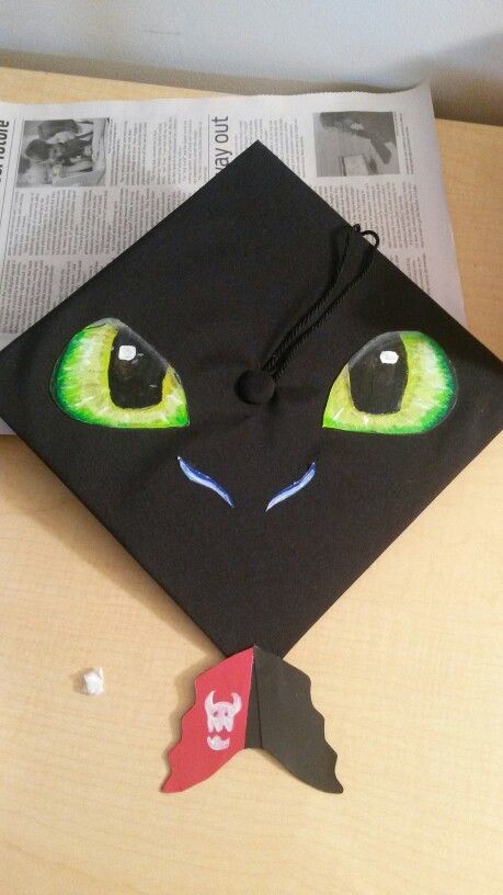 My '15 Toothless graduation cap with a dangling tail on the back. Graduation Cap Designs How To Train Your Dragon, Miraculous Ladybug Graduation Cap, Jurassic Park Graduation Cap, Httyd Graduation Cap, How To Train Your Dragon Graduation Cap, Disney Grad Caps, Disney Graduation Cap, Grad Hats, Graduation Hats