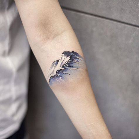 A watercolor snow mountain inked on the left forearm by tattooist Chenjie Snow Mountain Tattoo, Snowy Owl Tattoo, Snowboard Tattoo, Watercolor Mountains Tattoo, Reflection Tattoo, Wrist Tatoo, Leopard Print Tattoos, Watercolor Snow, Winter Tattoo