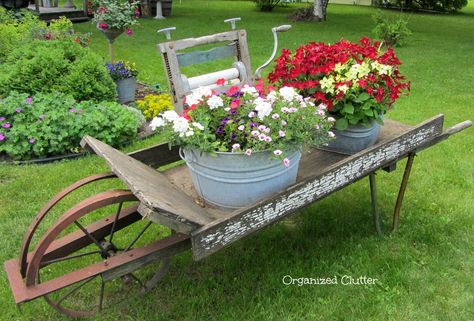 Weathered Wheelbarrow & Laundry Tub Planteres www.organizedclutterqueen.blogspot.com Wood Wheelbarrow, Shutter Shelf, Wooden Wheelbarrow, Flower Planting, Wheelbarrow Planter, Organized Clutter, Door Planter, Wheelbarrow Garden, Creative Planter