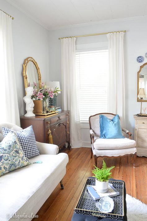 The living room in this hundred year old home features neutral tufted nailhead furniture, vintage bergere and channel back chairs, and lots of blue and white. Light Blue Grey Paint, Nailhead Furniture, Blue Painted Walls, Blue Gray Paint Colors, Teal Pillows, Light Blue Walls, Blue Gray Paint, Striped Chair, Boy’s Room