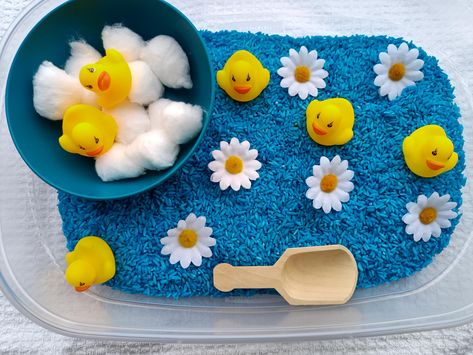 Rubber duck sensory bins!  Looking for something to keep your little one entertained? Sensory play will do just that! A perfect opportunity for kids to explore and guide their own play which leads to more engagement and learning These are great gift ideas for birthdays or Christmas gift for little ones! Below is what is included 3- (5"x7") bags of blue rice ( each batch is homemade so color may vary compared to pictures above) 12 - cotton balls 6- rubber ducks 1 - Wooden scoop 1- blue bowl 6 - f Edible Sensory Play, April Preschool, Toddler Sensory Bins, Blue Rice, Baby Sensory Play, Sensory Activities Toddlers, Toddler Sensory, Tuff Tray, Cup Of Rice