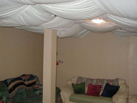 Basements are often thought of as casual spaces. Not generally frequently visited (and sometimes used as storerooms), you might not put a lot of thoug... | Get Wacky with Creative Fabric Ceiling #Basement #BasementCeiling #BasementCeilingIdeas #CeilingIdeas #DecoratedLife Aquarium Nursery, Basement Window Replacement, Unfinished Basement Ceiling, Drop Ceilings, Basement Ceiling Options, Basement Ceiling Ideas, Ceiling Options, Fabric Ceiling, Basement Layout