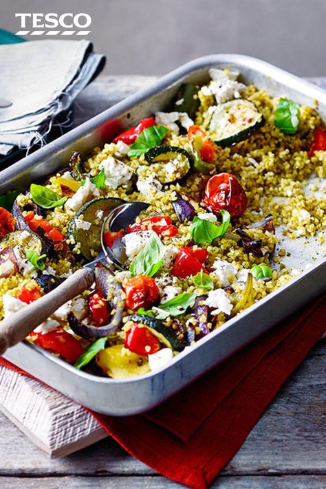 Get this easy one-dish traybake in the oven tonight for a speedy vegetarian dinner. Combining caramelised Mediterranean veg, pesto, bulgar wheat and crumbly Greek-style salad cheese, it's a winning midweek meal. | Tesco Tray Bake Vegetarian, Vegetarian Tray Bake Recipes, Midweek Meals Vegetarian, Tray Bakes Dinner, Bulgar Wheat Recipes, Veggie Party Food, Tray Meals, Bulgar Wheat Salad, Vege Meals