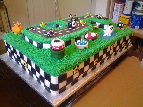 Photo 1 of 2. My oldest son's 5th birthday cake request. Mario Kart. This chocolate cake is two commercial full sheet cakes stacked on top of one another and a cake in the shape of the number 5 on top. Sides are marshmallow fondant as well as the Super Mario characters, road and water. The grass is piped buttercream. The only non-edible decorations are the pull back racers on the road. This 60 pound cake took a whooping 25 hours. But well worth it for Mama's #1 customer! Mario Race Track Cake, Mario Kart Sheet Cake, Super Mario Rainbow Road Cake, Mariokart Rainbow Road Cake, Mario Kart Cake Buttercream, Super Mario Tiered Cake, Race Track Cake, Mario Kart Cake, Birthday Cupcakes For Women