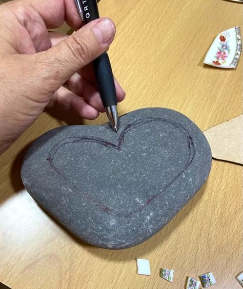 After a beautiful walk on holiday along a pretty cobbled beach, I just fell I love with the variety of ancient smooth sea washed stones . I stumbled across a sort of heart shaped one and decided to try creating unique mosaic on it using vintage crockery. I begin by drawing a heart shape onto the surface of stone with a pen. This gives a rough outline to work within. I use wheeled tile nippers to break up some old ceramic saucers and cups and find the little floral designs for my he… Drawing A Heart, Heart Shaped Rocks, Mosaic Rocks, Vintage Crockery, Mosaic Tile Art, Stone Crafts, Mosaic Stone, Beach Stones, Tile Art