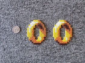 Today I made a Pac Man  ghost (orange) and rings from Sonic The Hedgehog . I love the rings. I want to make it four times as big. Perler Bead Sonic The Hedgehog, Lord Of The Rings Perler Beads, Ghost Perler Beads, Sonic Rings, Pac Man Ghost, Melt Beads Patterns, Black Fingers, Easy Perler Bead Patterns, Perler Creations