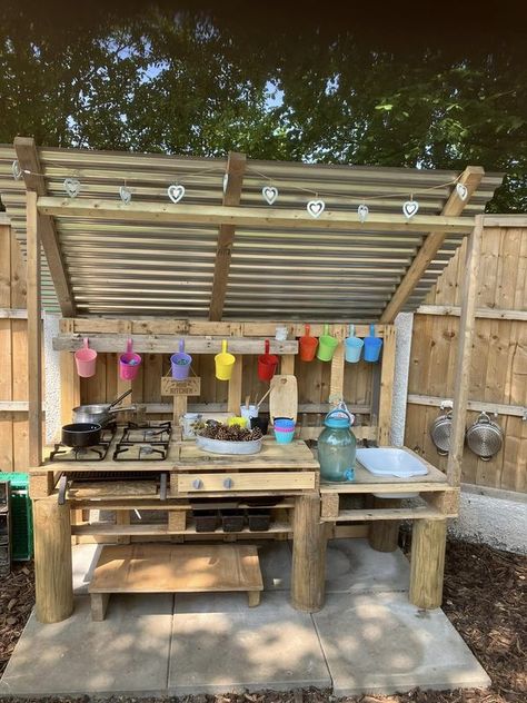 Mud Kitchen Play | We built a mud kitchen in the garden and added a corrugated roof to protect from the elements - it’s been a real hit and the children use scissors t... | Facebook Mud Kitchen With Roof, Painted Mud Kitchen, Kid Backyard, Eyfs Outdoor Area, Corrugated Roof, Mud Kitchen For Kids, Mud Kitchens, Outdoor Kids Play Area, Play Area Backyard