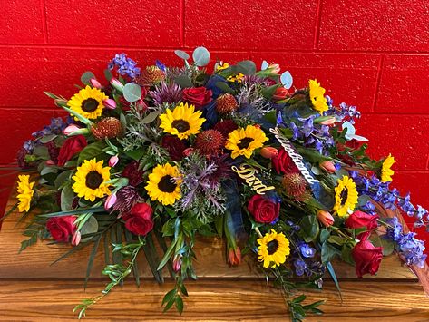 A blend of deeply colored summer flowers, including sunflowers, delphinium, roses, mums, kale and more Summer Casket Spray, Western Casket Spray, Flowers Red Rose, Rose And Sunflower, Yellow And White Casket Spray, Rich Summer, Men’s Casket Spray, Red Rose Casket Spray, Casket Spray