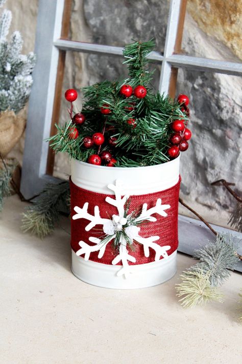 painted white tin can with red ribbon and white wooden snowflake Decorating Cans Tin, Diy Christmas Tin Cans, Diy Tin Can Projects Craft Ideas, Tin Christmas Decor, Tin Can Christmas Decorations, Tin Can Crafts Diy Christmas, Coffee Can Christmas Crafts, Metal Can Crafts, Tin Can Christmas Crafts