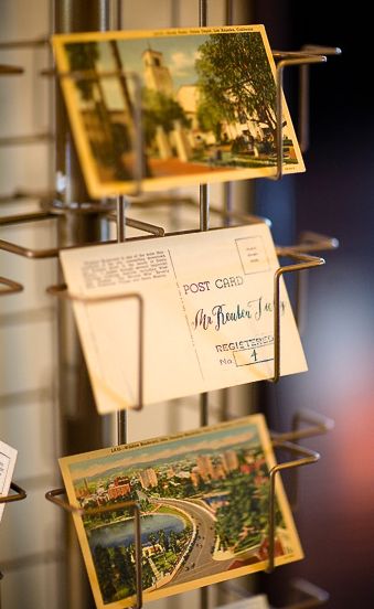 Vintage postcard stand for wedding table assignments- Great idea! Postcard Display Stand, Post Card Wedding Seating Chart, Postcard Seating Chart, Miniature Bookstore, Table Assignments Wedding, Postcard Stand, Wedding Table Assignments, Casablanca Wedding, Postcard Rack