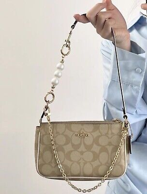 Find ideas๏ฟฝand inspiration for NWT Coach Nolita 19 In Signature Canvas c3308 + Pearl Chain + Wallet CQ145, Bags Coach Bags With Charms, Coach Nolita 19 Outfit, Cute Coach Bags, Coach Purse Aesthetic, Coach Bags Aesthetic, Coach Bags Handbags, Purses Aesthetic, Coach Bag Outfit, Dream Purse