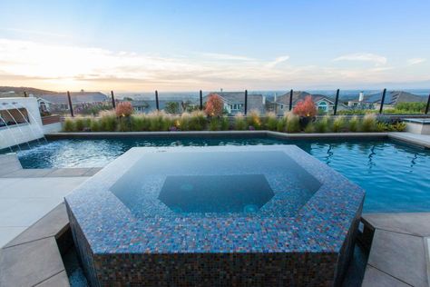 Water+is+overflowing+out+of+this+hexagonal+hot+tub+creating+a+beautiful+reflective+finish+over+the+iridescent+blue,+turquoise+and+brown+tiles.+Three+levels+create+a+descending+shape+and+built+in+bench+seating+within+the+tub.+The+concrete+patio+frames+one+side+of+the+hot+tub+while+the+other+opens+into+the+swimming+pool.+ Tile Hot Tub, Swimming Pool Renovation, Built In Bench Seating, Colorful Tile, Tub Design, Hot Tub Designs, Pool Renovation, Honeycomb Shape, Colourful Tile