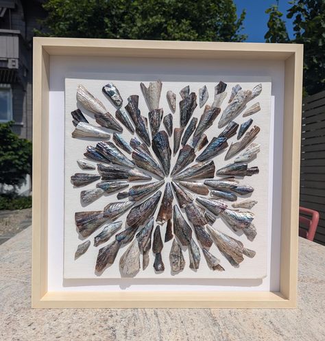 Immerse yourself in the beauty of the ocean with this stunning seashell collage, handcrafted using delicate pen shells from Florida. Each piece is meticulously arranged to create a captivating display of natural mother-of-pearl shimmer. Dimensions of the frame: - Height 52 cm / 20.47 inches - Width 52 cm / 20.47 inches This elegant statement piece is perfect for adding a touch of coastal charm to your home.  Imagine it displayed on a shelf, mantle, or hung as a unique wall accent.  The natural a Shell Stepping Stones, Seashell Diys, Shell Canvas Art, Shell Displays, Sea Shell Wall Art, Seashell Collage, Seashell Shadow Boxes, Seashell Artwork, Seashell Display