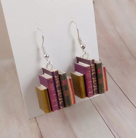 Nice that you stopped by  Our latest earring creation "Book Series Old" is a great gift idea - not just for book lovers. 📚 Each earring consists of five small closed books, which we have lovingly created by hand. The booklets show old, antique book designs. The books can still be seen through the leather-like structured surface of the books more like antique, old books. The core of the booklet is made of super light balsa wood, which is why these earrings are absolutely light and offer absolute Mini Book Earrings Diy, Book Earrings Diy, Bookish Earrings, Paper Art Christmas, Mini Book Earrings, Old Earrings, Souvenir Art, Book Earrings, Quirky Earrings