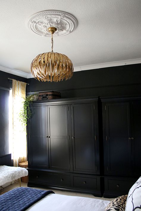 black bedroom wardrobes with gold light fixture and ornate gold mirror - see more on www.swoonworthy.co.uk Black Wardrobe Bedroom, Gold Wardrobe, Moody Interior Design, Glam Lighting, London Interior Design, Black Rooms, Black Interior Design, Bedroom Light Fixtures, Minimalist Bedroom Design