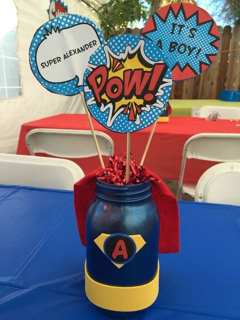 a super hero themed centerpiece with comics details Superman Baby Shower, Marvel Baby Shower, Superhero Centerpiece, Baby Dinosaur Party, Batman Baby Shower, Dinosaur Baby Shower Theme, Batman Baby, Baby Shower Ideas For Boys, Superhero Baby Shower