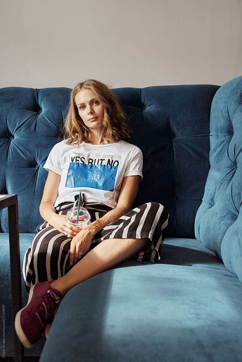 Portrait of young attractive blond woman in stylish casual outfit sitting on comfortable couch with drink and looking at camera Sitting On Couch Reference, Flash Poses, Couch Portrait, Woman On Couch, Airbnb Photoshoot, Couch Photography, Book Reels, Sitting On A Couch, Woman Resting