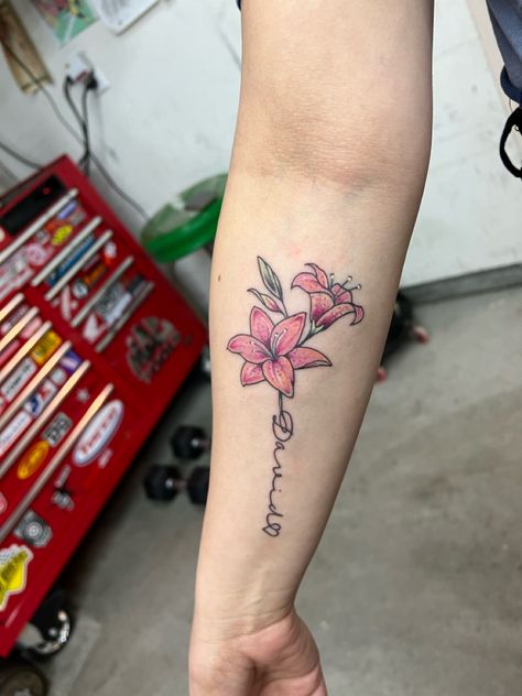 Name tattoo with lily flowers Name Stem Flower Tattoo, Lily Tattoo With Name, Lily Name Tattoo, Nancy Tattoo, Flower With Name Tattoo, Small Lily Tattoo, Flower Name Tattoo, Lilly Flower Tattoo, Letter R Tattoo