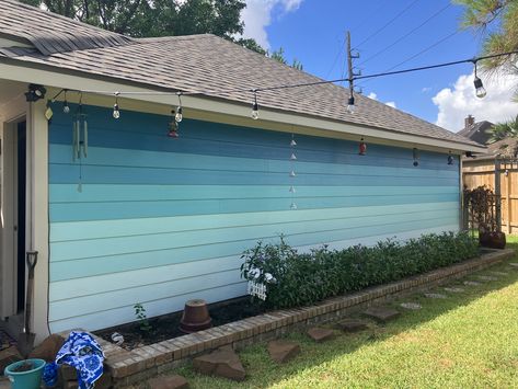 I wanted to to turn my boring beige garage wall (in backyard) into an accent wall, so i did this blue ombre paint job! Backyard Wall Ideas Paint, Mural On Vinyl Siding, Beach Murals Outdoor, Garage Wall Mural Ideas, Ombre House Exterior, Driveway Divider, Wall In Backyard, Garage Accent Wall, Painted Fences Ideas Backyards