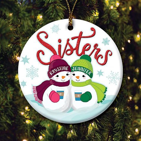 Two Snowmen Sisters Personalized Ceramic Ornament Add a touch of sisterly love to your Christmas tree with this customizable snowman sister ornament. Adorably sweet, this unique design is sure to light up your tree for years to come. Stars two sisters you can personalize with names on the brims of their winter hats. Create a delightful addition to your holiday celebrations, or a fabulous gift for beloved sister, when you personalize this outstanding ornament.  What You Get      Ornament     Gold string for hanging Painted Round Wood Christmas Ornaments, Gnome Plates, Sister Christmas Ornaments, Sister Ornament, Friendship Ornaments, Circle Crafts, Snowman Design, Pot Painting, Christmas Accents