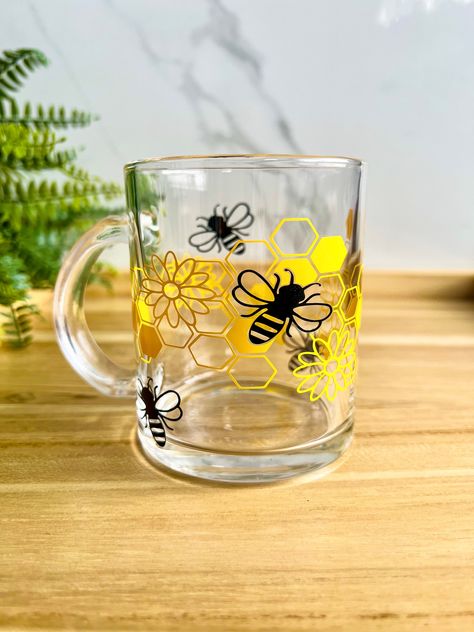 Honey Bee Daisy Glass Mug 13 ounce glass mug designed with premium permanent vinyl This glass mug works great for both HOT and COLD drinks ❤️ Cup design is created by using Yellow and Black  premium permanent vinyl. ✨Looking for the Honey Bee Daisy Glass Cup version?! Check out this listing! https://www.etsy.com/tiasdreamdesignco/listing/1513704185 ✨Check out our Boho Daisy shaped cork coasters! https://www.etsy.com/Tiasdreamdesignco/listing/1470420940 Care Instructions: 1. Please hand wash ONLY (No dishwasher) 2. Do not soak 3. Do not scrub the design on the glass  4. Please do not use this glass in the microwave Glass Mugs With Vinyl, Bee Lover Gifts, Glass Coffee Mug, Daisy Wallpaper, Glass Coffee Cups, Diy Cups, Glass Coffee Mugs, Jar Diy, Honey Jar