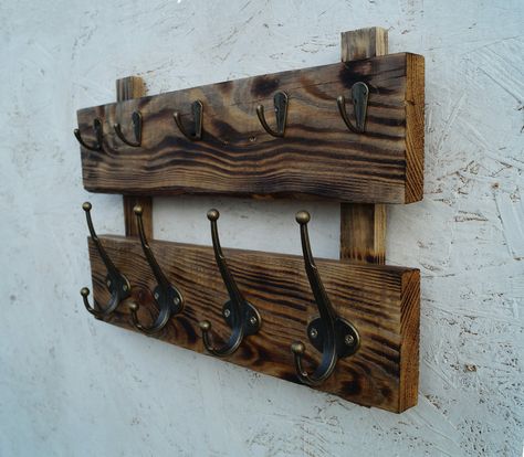 This wooden coat rack wall mount is the perfect decor for your home. On the top panel are small hooks for keys. On the bottom - powerful hooks for clothes. The coat rack is made of natural wood. This is old wood. I restored it. Reclaimed wood exhibits some gorgeous features - knots, old nail/screw marks, and grain designs that look amazing. Repeat is not possible. Since the pattern of the tree is unique. This is the value of such products. Other options are Barnwood coat rack- https://etsy.me/3a Wooden Hat And Coat Rack, Barnwood Coat Rack, Barnwood Projects, Burnt Wood Finish, Coat Rack Wall Mount, Wooden Coat Hooks, Wood Coat Rack, Rustic Wall Shelves, Rough Wood