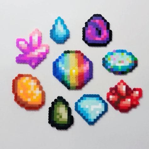 Delve into the pixelated beauty of Stardew Valley with our Perler Minerals Keychains & Magnets! Inspired by the vibrant gemstones found within the game, each piece is meticulously crafted to capture the essence of these precious minerals. Whether you're a dedicated farmer or a casual gamer, these unique accessories add a touch of whimsy to your everyday life. Perfect for adorning your keys, backpack, or fridge, these handcrafted items are sure to spark joy and nostalgia in any Stardew Valley enthusiast. Explore our collection and add a dash of pixelated magic to your world today! (Frozen Tear is too small to be a magnet) 🌈 Versatile Design: Use it as a charming keychain to add a touch of cuteness to your bags or keys. Alternatively, turn it into a magnetic masterpiece for your fridge or m Perler Bead Gem Patterns, Stardew Perler Bead Patterns, Peler Beads Stardew Valley, Stardew Valley Items, Stardew Valley Perler Bead Patterns, Stardew Perler, Stardew Valley Perler Beads, Stardew Valley Junimo Perler Beads, D&d Perler Beads