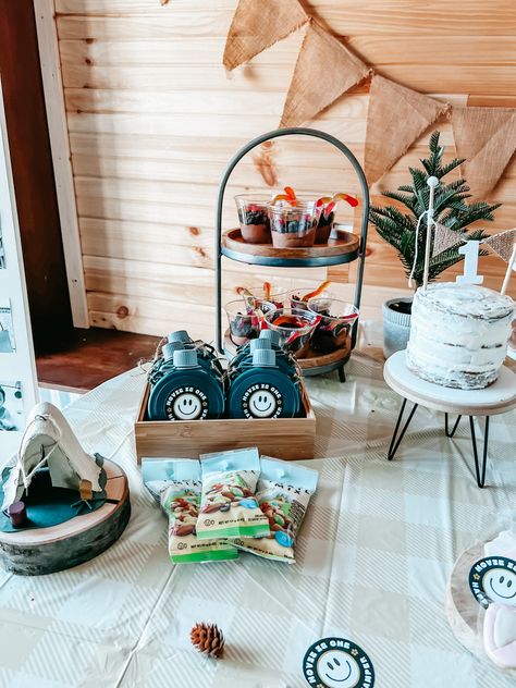 With having a February Michigan winter baby, I wanted a first birthday theme that was season appropriate. Her party would have to be indoors but this theme helped bring the outoors in! Dirt cups, camp themed cookies, “happy trails” trail mix favors, a cozy tent setup, and a menu of grilled burgers and hot dogs! I am so happy with how it all turned out. I hope it inspires you! #onehappycamper #firstbirthdayparty #themeparties One Happy Camper First Birthday Party Favors, Happy Camper Party Favors, Vintage Camp Birthday Party, One Happy Camper First Birthday Activities, One Happy Camper Favors, One Happy Camper Invitation, One Happy Camper Dessert Table, Hiking First Birthday Theme, One Happy Camper Party Favors