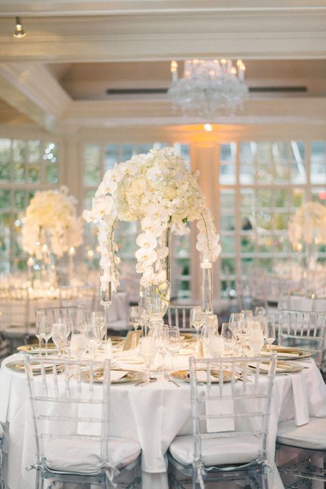 Glass Chairs Wedding, All White Wedding Reception, White Orchid Centerpiece, Orchid Centerpieces Wedding, Disney Wedding Centerpieces, Catholic Traditions, Classic Wedding Reception, White Wedding Reception, White Centerpieces