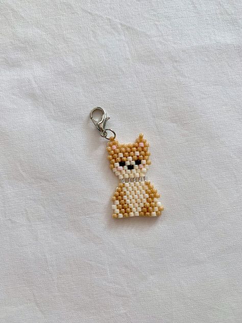 Adorable blushing corgi/shiba inu charms anyone? If you're a dog lover, or you have a corgi at home, this is the perfect little stitch marker that can accompany you on all your knitting/crochet journeys AND remind you of your sweet puppy! This marker is individually hand weaved with Japanese glass beads. I have selected opposing bead finishes -- matte cream beads and glossy light brown beads in order to make the overall design pop!  Size:  3g or 0.1 oz 2.5cm or 1'' Endings:  1. Jump rings -- fit Dog Bead Pattern, Bead Pets Pattern, Bead Animals Patterns, Dog Knitting, Pony Bead Animals, Pony Bead Projects, Miyuki Beads Pattern, Diy Seed Bead Earrings, Shiba Inu Puppy