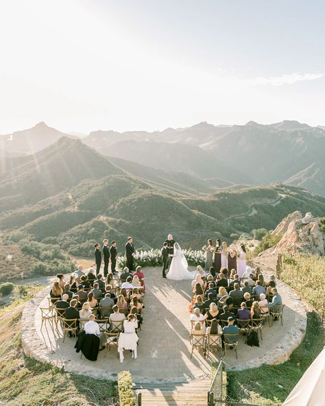 The couple's Christian ceremony, which included a ring exchange, was officiated by one of their best friend's father. It took place on the estate's helipad, which overlooked the region's sweeping hillsides. As if that backdrop weren't enough, Poppy Design Co. crafted a floral crescent to frame the bride and groom. #weddingceremony #uniqueweddingvenue #outdoorweddingideas #stunningwedding | Martha Stewart Weddings - Guests Were Blown Away by the Ceremony Space at This Formal California Wedding Wedding Ceremony Ideas, Ring Exchange, Malibu Wedding, Poppy Design, Unique Wedding Venues, Christian Wedding, Ceremony Arch, Martha Stewart Weddings, Floral Arch