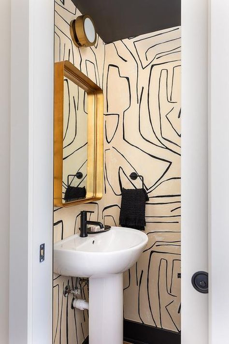 Modern powder room features cream and black Kelly Wearstler Graffito wallpaper, a black ceiling and a curved brass mirror over a curved pedestal sink accented with an oil rubbed bronze faucet. Graffito Wallpaper, Wallpaper Powder Room, Modern Powder Room, Black Kelly, Powder Room Wallpaper, Wallpaper Ceiling, Powder Room Small, Bathroom Design Decor, Pedestal Sink