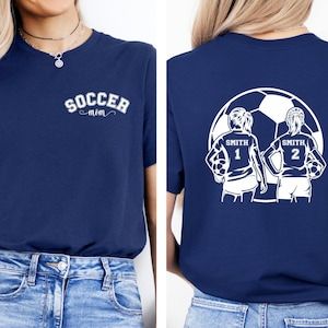 Show off your soccer fanaticism with this custom 2-player shirt!  The front and back feature personalized names and numbers, making it the ultimate game day shirt for any proud soccer mom.  #soccermom #momoftwins Soccer Mom Gifts, Soccer Mom Shirt, Matching Mom, Soccer Girl, Soccer Mom, Soccer Shirts, Game Day Shirts, Sports Shirts, Mom Shirts