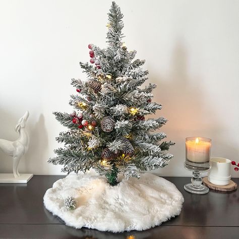 PRICES MAY VARY. CREATING WINTER WONDERLAND: Each small Christmas tree includes a mini Christmas tree skirt (15 in) of snow white faux fur, adding an extra touch of soft. As our gift to you, this mini tree skirt can even be used under other mini trees you may have. BATTERY-POWERED CONVENIENCE: The lights on this mini Christmas tree are battery-powered, requiring just 3 AA batteries (not included), so you can place your tree anywhere without the hassle of cords or outlets. PERFECTLY SIZED: Standi Small Christmas Trees On Table, Mini Tree Skirt, Desktop Christmas Tree, Christmas Tree Artificial, Faux Fur Tree Skirt, Christmas Tree With Lights, Tree With Lights, Fur Tree, Tree Artificial