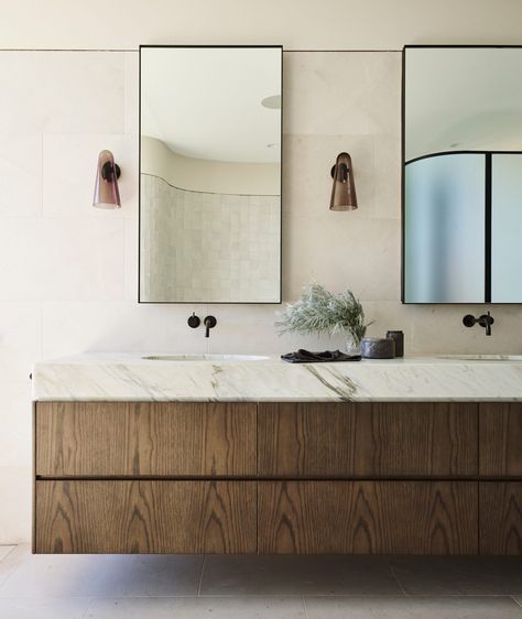 This serene primary bath features a floating vanity outfitted in rich wood and sleek black finishes. + floating vanity + marble countertop + primary bathroom + bathroom sconces + wall mounted faucet | Design by Decus Interiors Decus Interiors, Joinery Design, Loft Interior, Est Living, Custom Furniture Design, Style Loft, Floating Vanity, Hanging Ceiling Lights, Style Deco