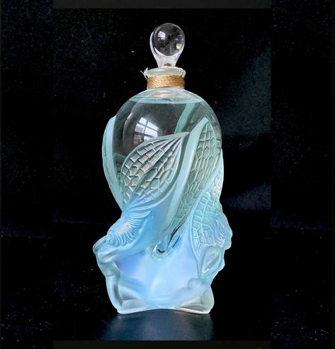 Lalique de Lalique Collectible Crystal Flacon - 2002 Limited Edition "Les Elfes".. Limited, Numbered and Signed Edition. "A symbol of mystery and magic, the Limited Edition Les Elves depicts a pair of whimsical elves holding a crystal bottle. The mythical creatures protect the creation that is as beautiful and unique as they are: enfolded in the hollow of their wings lies a masterfully hand blown and satin finished bottle." A Lalique limited edition bottle created in 2002 having gold highlights Unique Perfume Bottles, Crystal Bottle, Pretty Perfume Bottles, Witch Diy, Lalique Crystal, Art Of Glass, Gold Highlights, Vintage Bottles, Potion Bottle