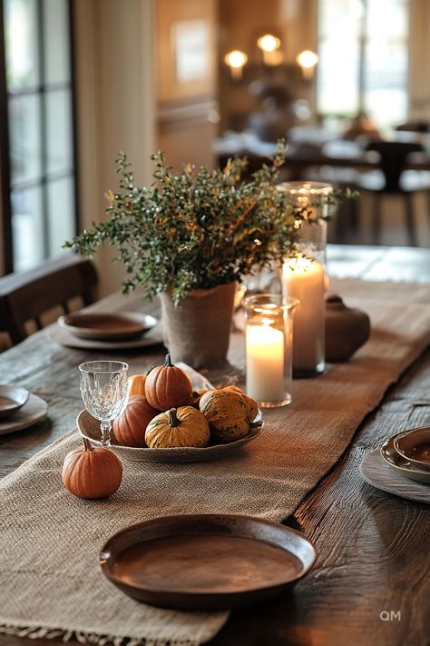 A rustic coffee table decorated for fall with small pumpkins, a green foliage centerpiece, candles, and a burlap table runner. Perfect fall coffee table decor. Mini Pumpkin Tablescape, Pumpkin Tablescape Fall Decorating, Thanksgiving Decorations Minimalist, Simple Everyday Table Centerpieces, Minimalist Thanksgiving Table Settings, Simple Fall Arrangements, Fall Tablescapes Simple, November House Decor, Small Thanksgiving Table Decor