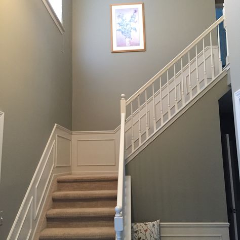 Benjamin Moore River Reflections updates a sage green foyer. Sage Green Foyer, Sage Green And White Hallway, Sage Green Panelling Hallway, Sage Green Stairs, Sage Green Staircase, Green And Cream Hallway, Sage Green Hallway And Stairs, Sage Hallway Ideas, Pale Green Hallway