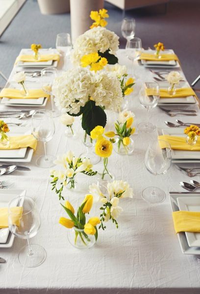 Yellow tulips, ranunculus, freesia, and white hydrangea in large bases and bud vases atop a crinkle ivory linen and yellow napkins Lemon Themed Bridal Shower, Yellow Wedding Theme, Yellow Napkins, Tulip Wedding, White Hydrangeas, Flowers Arrangements, Yellow Tulips, Easter Centerpieces, Trendy Flowers