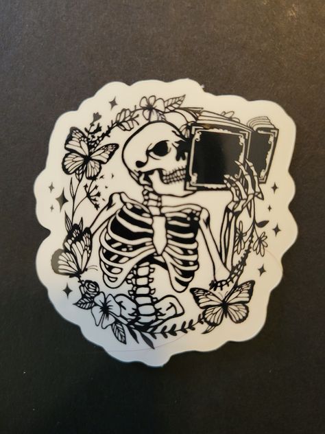 "This super cute vinyl sticker is made from high quality, waterproof vinyl with a glossy finish. Perfect for your kindle, water bottle, laptop, or whatever your imagination tells you! Measurements: 1.75\" x 2\" Materials: Vinyl, Glossy Finish  Care: Waterproof, Dishwasher Safe, and UV protected" Book Skeleton Tattoo, Skeleton Reading Book Tattoo, Reading Skeleton, Skeleton Stickers Printable, Skeleton Reading Book, Skeleton Sticker, Sticker Printer, Black And White Stickers, Sketch Poses