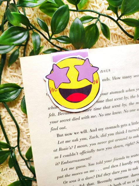 Smiling Face with Stars Magnetic Bookmark This is the perfect gift for book and reading lovers! Use it on your diary, magazines, books, journals... Handmade. I cut to size the bookmarks personally, cut and glue the magnet. ITEM DETAILS: - 200 gsm card - 80gsm premium matte paper - Glossy film protection - Craft insides SIZE: 5x4.8cm appx (closed) Emoji Bookmarks, Cut And Glue, Face Emoji, Magnetic Bookmarks, Cute Stationery, Gifts For Readers, Happy Face, Smile Face, Smiley Face