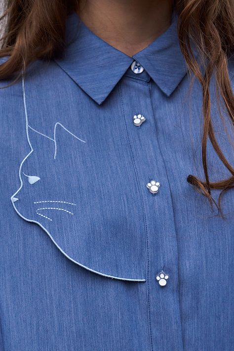 Introducing a new member of the Miss Patina cat-inspired design family. Simple yet sleek shape with a loose fit cut. This dress is elevated by our signature cat silhouette embroidery on the front right. With adorable paw-shaped buttons and blue and white buttons down the front with concealed pockets on both sides. Effortlessly style as a dress or layer as an overshirt. Crafted from a midweight rayon mix with a denim fabric giving you a more lightweight feel overall. Pair with brown ankle boots a Cut Shirt Designs, Silhouette Embroidery, Miss Patina, Cable Knit Dress, Western Tops, Trendy Fashion Tops, Embroidery On Clothes, Mode Casual, Cat Silhouette