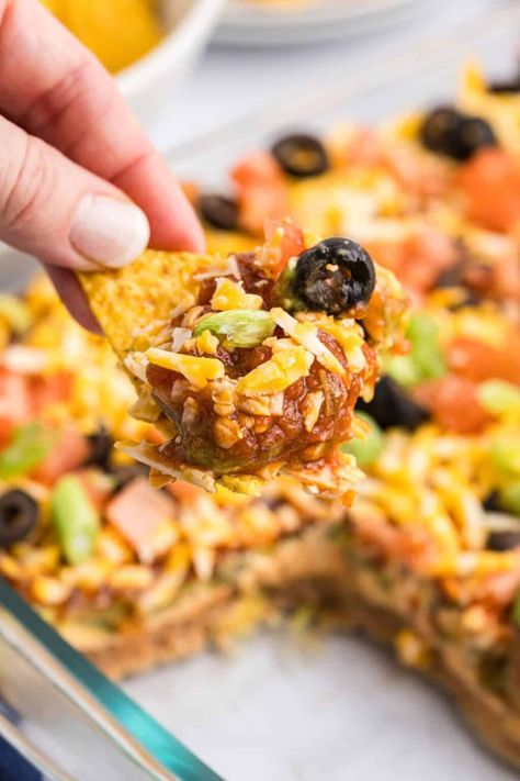 Perfect for parties and potlucks, this Mexican 7 Layer Dip is easy and fun make! This dip features layers of all your favorite taco ingredients including refined beans, guacamole, and salsa. Seven layer dip is an epic entree or appetizer that everyone will keep coming back for! Layered Dips For Parties, 7 Layer Dip Mexican, Mexican 7 Layer Dip, Seven Layer Bean Dip, 7 Layer Mexican Dip, Seven Layer Taco Dip, 7 Layer Bean Dip, Layer Taco Dip, Taco Dip Easy