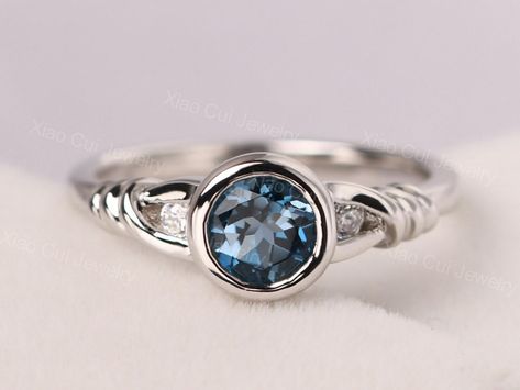 Welcome to my shop, you can find many beautiful gemstone jewelry here, and you also can ask for customized service. Main Stone: Real London blue topaz , round cut 6 mm Accent Stones: CZ Metal: 925 sterling silver plated with rhodium so as to protect the ring from tarnish and keep it shinning. I also can provide metal options such as 14k solid yellow/white/rose gold Setting: bezel setting more rings: https://www.etsy.com/shop/XCjewelryStudio?ref=hdr_shop_menu It's quite comfortable for wearing an Ring With Blue Stone, Twist Engagement Ring, Meaningful Rings, November Birthstone Ring, Swiss Blue Topaz Ring, Engagement Rings Twisted, Bezel Engagement Ring, Engagement Ring For Her, Topaz Engagement Ring