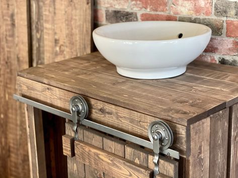 This Rustic Barn Door Style Bathroom Vanity will be perfect for any bathroom. PERFECT Gift for New Homeowners PERFECT Wedding Gift PERFECT Gift for Newlyweds PERFECT Gift for New Parents and more... Wood protection: Waterproof Lacquer with Gloss finish. Hardware color: Black with Gloss finish. Made to order. Fully custom sizes available. Fully custom colors also available. Single Vessel Sink not included. NO predrilled holes * Mounting Location: Free-standing * Base Material: Solid Wood This bea Rustic Bathroom Designs Farmhouse Style, Bathroom Cabinet With Barn Doors, Rustic Showers, Farmhiuse Bathroom Vanity, Barn Wood Cabinets, Barnwood Vanity, Barn Door Sgyle Bathroom Vanity Plans, Rustic Bathroom Shower, Rustic Bathroom Vanity